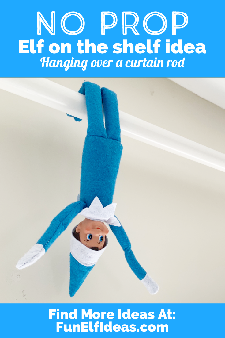 Elf on the shelf hanging over a curtain rod