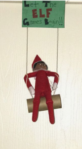 elf on the shelf announces his arrival with a sign reading "Let the elf games begin!"
