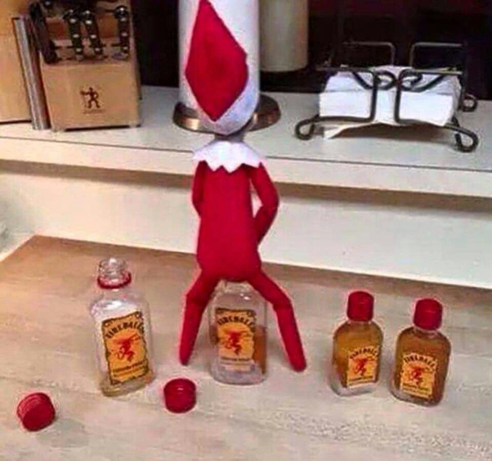 Elf on the shelf peeing into whiskey bottles.