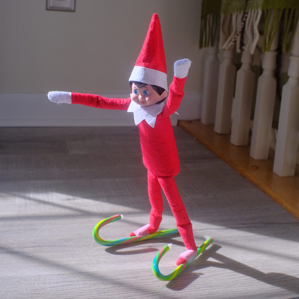Female elf on the shelf doll Going skiing with candy canes.