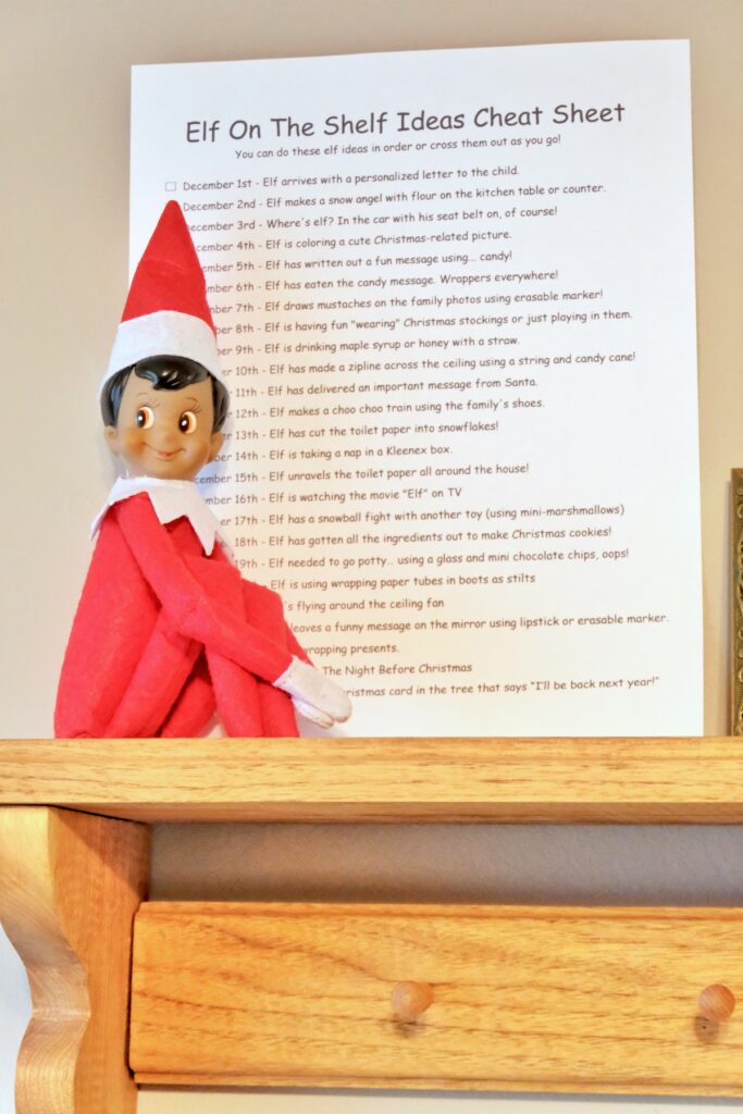 a dark skinned elf on the shelf doll sitting on a shelf with an elf on the shelf ideas cheat sheet
